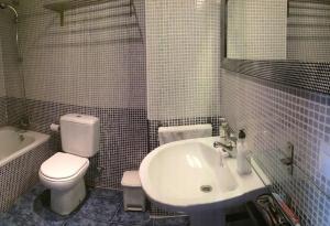 a bathroom with a white toilet and a sink at Mirador La Pita Azul in San José