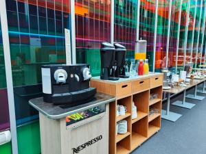 a coffee shop with a coffee maker on a counter at Sercotel Jardines de Uleta Suites in Vitoria-Gasteiz