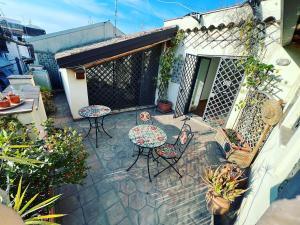 an outdoor patio with tables and chairs and plants at Bnb San Barnaba in Catania