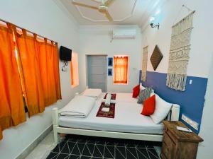 a bedroom with a bed with orange and blue walls at Jaisalmer Hostel Crowd in Jaisalmer
