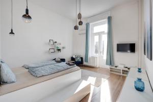 ein weißes Schlafzimmer mit einem Bett und einem TV in der Unterkunft Elizabeth Garden Apartment in Budapest