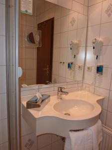 a bathroom with a sink and a mirror at Landhotel Mühle zu Gersbach in Gersbach