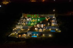uma casa grande com um sinal verde à noite em Skorponeria Bay Luxury Villas em Skroponeria
