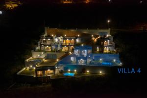 una grande casa illuminata di notte con luci di Skorponeria Bay Luxury Villas a Skroponeria