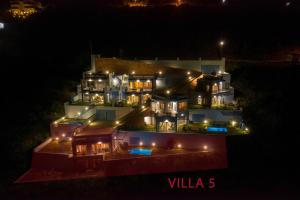 duży dom jest oświetlony w nocy w obiekcie Skorponeria Bay Luxury Villas w mieście Skroponeria