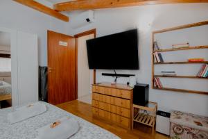 a bedroom with a flat screen tv on a wall at "La Casetta" tra Milano, Monza e i laghi di Como e Lecco in Cesano Maderno
