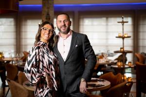 a man and a woman posing for a picture in a restaurant at Hôtel de la Tour in Melen