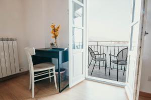 Zimmer mit einem Schreibtisch und Stühlen auf einem Balkon in der Unterkunft La casa sull'Isola Pescatori in Stresa