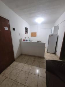 a kitchen with a counter and a refrigerator at Espaçosa kitnet em itapua 10 min da praia. in Vila Velha