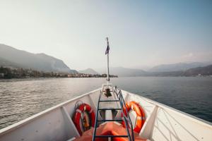 una barca sull'acqua con una bandiera di La casa sull'Isola Pescatori a Stresa