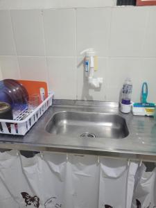 a kitchen counter with a stainless steel sink at Espaçosa kitnet em itapua 10 min da praia. in Vila Velha