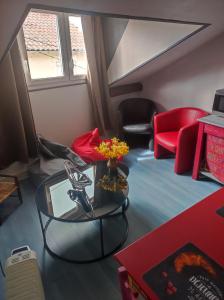 a living room with a table and a red chair at hô choucas in Chauvigny