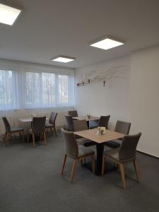 uma sala de conferências com mesas, cadeiras e janelas em BEST Hotel Garni em Olomouc