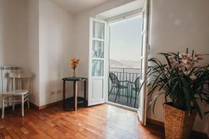 a living room with a door open to a balcony at La casa sull'Isola Pescatori in Stresa