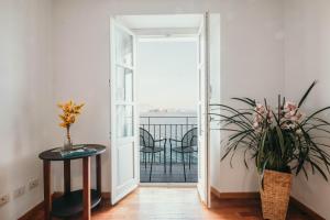 a hallway with a door open to a balcony with flowers at La casa sull'Isola Pescatori in Stresa