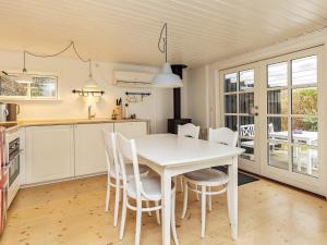 eine Küche mit einem weißen Tisch und Stühlen in der Unterkunft Holiday home Væggerløse CCXIV in Bøtø By