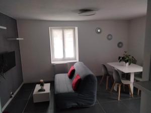 ein Wohnzimmer mit einem Sofa und einem Tisch in der Unterkunft Agréable appartement in Morbier