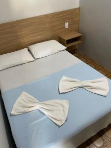 a bed with two white bows on it at Hotel Manarela in Imperatriz