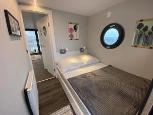 a small bedroom with a bed and a window at Hausboot Fjord Serina mit Biosauna in Schleswig in Schleswig