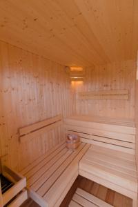 una sauna de madera con 2 bancos y un tazón. en Hausboot Fjord Serina mit Biosauna in Schleswig, en Schleswig