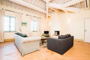 sala de estar con 2 sillas y chimenea en Luxury Apartment in Siena Resort, en Trequanda