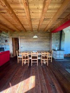 a dining room with a table and wooden ceilings at Chalet Oasi della Volpe in Cà Paini