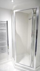 a shower with a glass door in a bathroom at Spacious apartment City Centre 5 guests long stay in Manchester