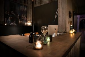 - un bar avec des bougies et une table avec un ordinateur portable dans l'établissement Hôtel de la Tour, à Melen