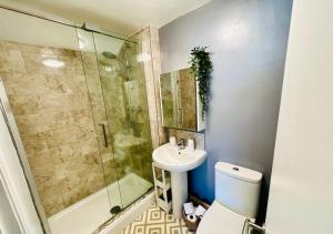 a bathroom with a shower and a toilet and a sink at Top Floor Apartment Overlooking Torquay Harbour Pet Friendly in Torquay