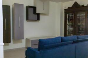 a living room with a blue couch and a cabinet at Laetitia Guesthouse in Sepino