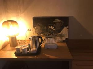 einem Tisch mit einer Lampe und einer Kaffeemaschine darauf in der Unterkunft Maisonette in Vigevano