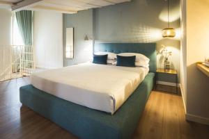 ein Schlafzimmer mit einem großen Bett mit blauen Akzenten in der Unterkunft Maisonette in Vigevano