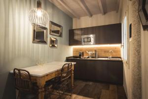 cocina con mesa, sillas y fregadero en Maisonette, en Vigevano