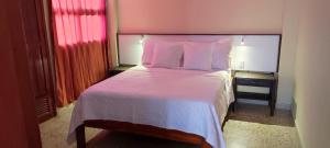 a bedroom with a large bed with pink sheets and pillows at Apartamento con vista al mar en la mejor zona de la ciudad genial para relax o trabajo in Ríohacha