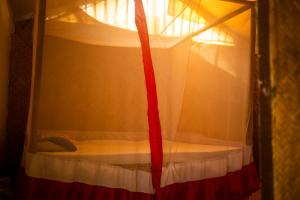 a bedroom with a canopy bed with a red ribbon at Yoga Culture Palolem in Palolem