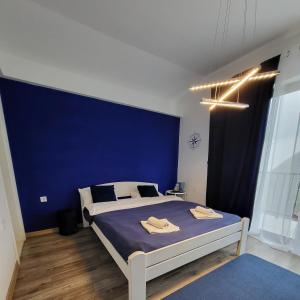 a bedroom with a large bed with a blue wall at Apartmani Sport Igalo in Herceg-Novi