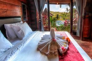 a bedroom with a white bed with a bow on it at THE DARA HILL in Nusa Penida +94 photos