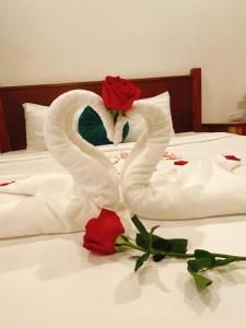 a white swan made out of roses on a bed at Opera Premier Hotel in Luang Prabang