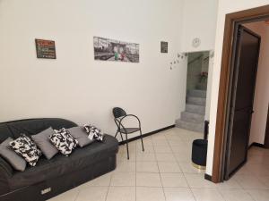 a living room with a black couch and a staircase at La Gardenia in Licodia Eubea