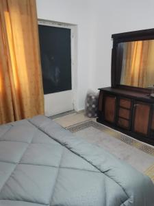 a bedroom with a bed and a tv and a window at Studeo for rent in Amman