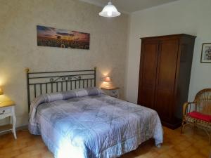 1 dormitorio con 1 cama, 2 mesas y armario en Agriturismo Casale Sant'Antonio, en Cascia