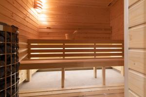 uma sauna com um banco numa sala de madeira em Apartamenty Sun & Snow Kalinowa z sauną em Szczyrk