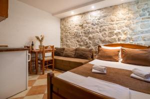 Cette chambre comprend deux lits, une cuisine et une table. dans l'établissement Little Bay Apartments, à Kotor