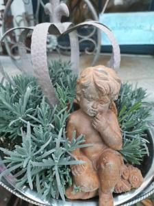 a statue of a little girl sitting in a plant at cafesahne u Pension in Dranske