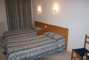 Hostal Gran Sol في يانسا: سريرين في غرفة فندق مع سريرين sidx sidx