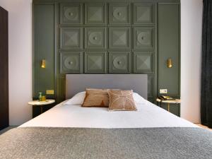 una camera da letto con un grande letto con due cuscini sopra di Hotel Damier Kortrijk a Courtrai