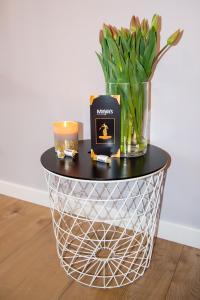 a table with a candle and a vase of flowers at Maya's Flats & Resorts 62 - 3 rooms apartment BASTION WALOWA Gdańsk in Gdańsk