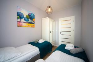 a bedroom with two beds and a painting on the wall at Maya's Flats & Resorts 62 - 3 rooms apartment BASTION WALOWA Gdańsk in Gdańsk