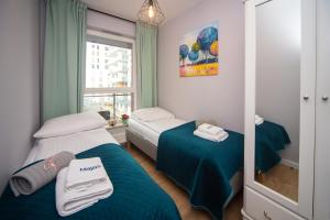 a small room with two beds and a mirror at Maya's Flats & Resorts 62 - 3 rooms apartment BASTION WALOWA Gdańsk in Gdańsk