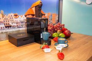 a table with strawberries and fruit and a coffee maker at Maya's Flats & Resorts 62 - 3 rooms apartment BASTION WALOWA Gdańsk in Gdańsk